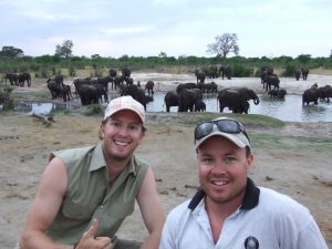 Two men enjoying the a herd of elephants on their Covid safe African safari.
