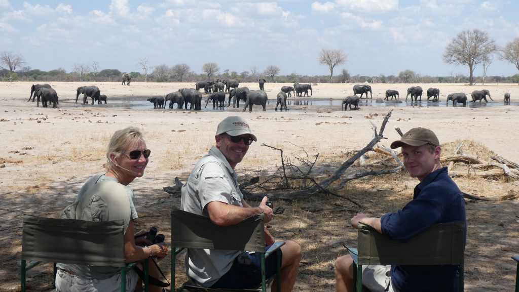 Mum , Dad and son enjying elephants at a waterhole and being Covid safe.
