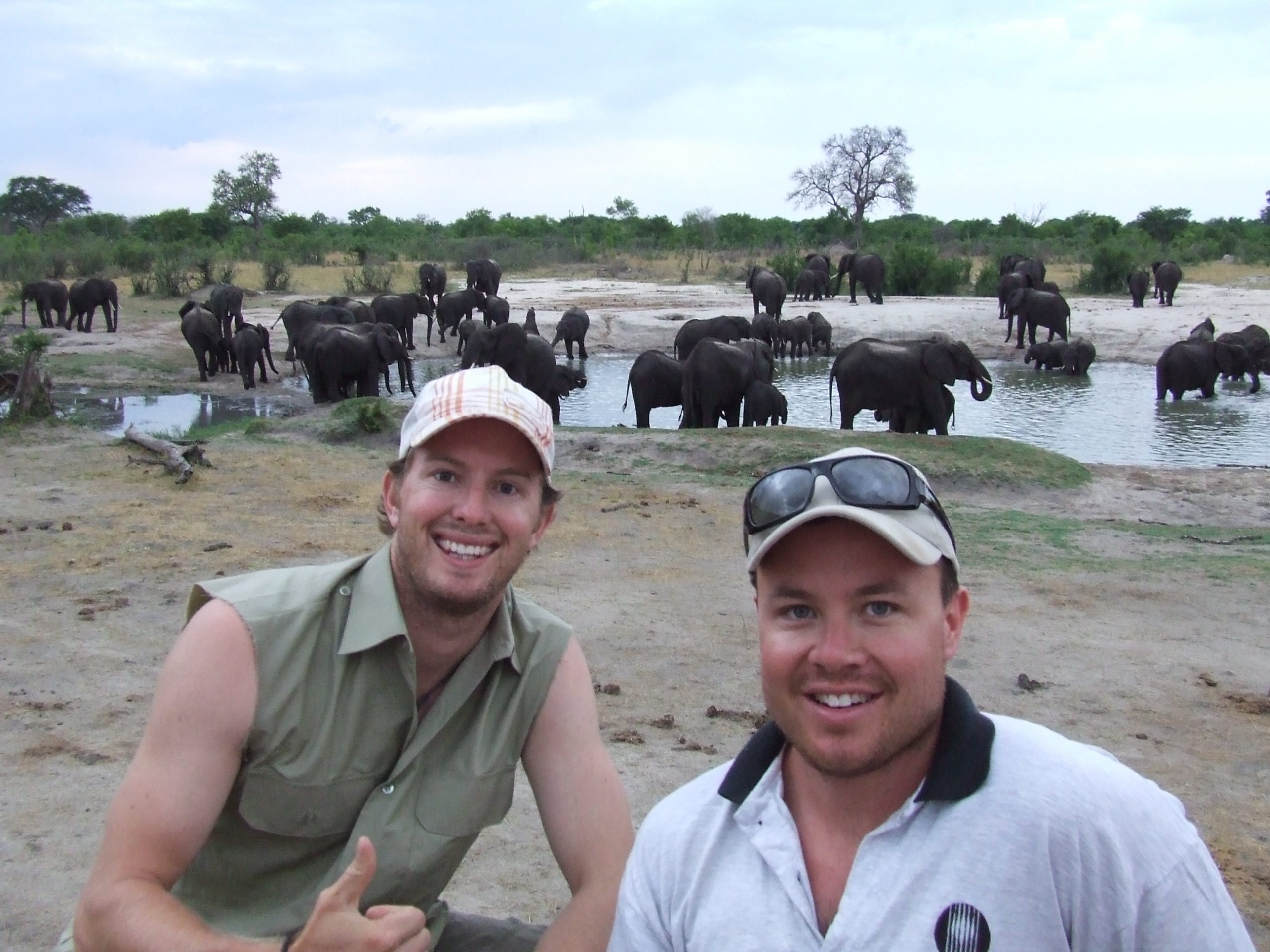 Two men enjoying the a herd of elephants on their Covid safe African safari.